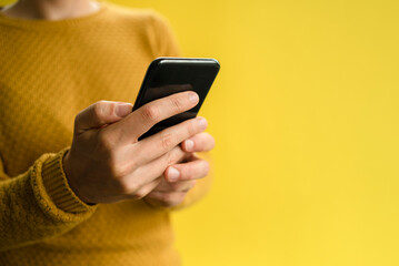 Woman in yellow sweater using smartphone