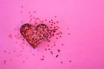 Heart shaped red sparkles on pink background