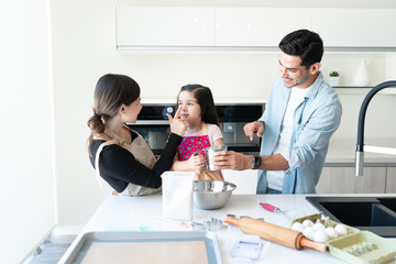 Smiling Man With Family Cooking At Home
