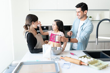 Parents Having Fun While Preparing Food With Daughter