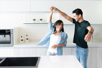Happy Latin Couple Dancing In Kitchen