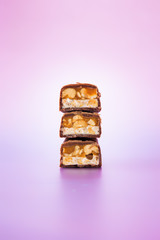 Stacked chocolate bars, cut in half, isolated on colorful background.