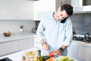 Man Using Phone While Preparing Food In Kitchen