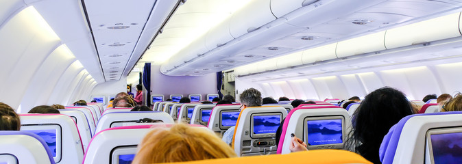 Passenger seat on the plane. Empty plane interior with few people and stewardess during coronavirus...