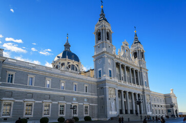Fototapeta na wymiar Madrid/Spain/21.23.2014. Facade and bell towers of Cathedral of the Almudena Cathedral of Santa María la Real de la Almudena. Baroque Catholic cathedral known for its colorful chapels.