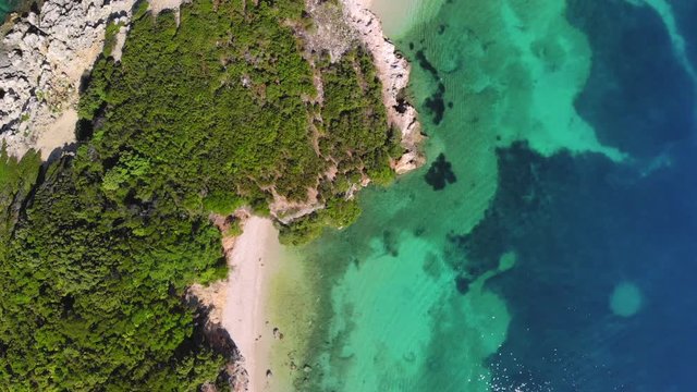 Top-down view of the rocky seashore with beautiful sandy beaches and turquoise water on a sunny day. Albania, Ksamil.
