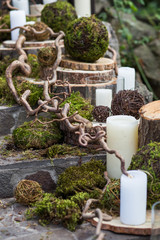 
Large white candles, moss and tree branches decorate the stairs at the wedding ceremony.