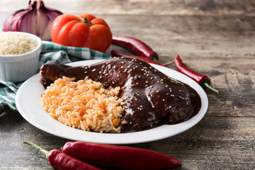 Traditional mole Poblano with rice in plate on wooden table. Copy space	