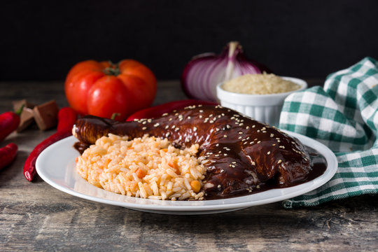 Traditional mole Poblano with rice in plate on wooden table	