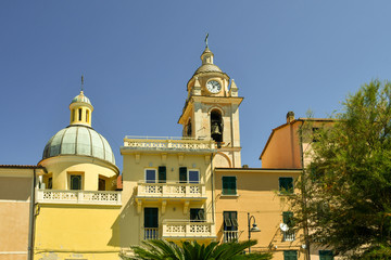 Top of the historic centre of San Terenzo with the dome and the bell tower of the old church of Santa Maria Assunta against clear blue sky, Liguria, Italy