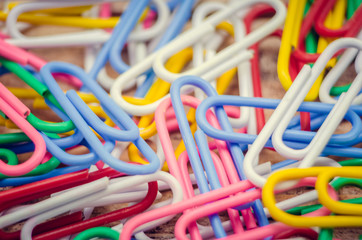 Macro photo of multicolored paper clips. Bright background made of colored paper clips, close-up