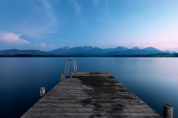 Fototapeta premium Steg am Hopfensee im Allgäu im Sommer zur blauen Stunde