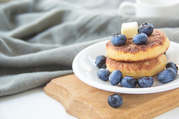 A healthy breakfast of pancakes, berries, butter, and honey