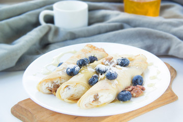 A healthy breakfast of pancakes, berries, butter, and honey