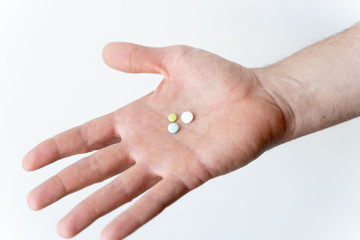 Hand with pills on a white background