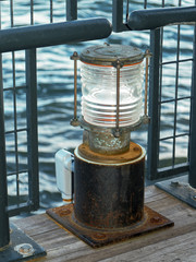 Decorative electrified replica of an old time dock light mounted on the wooden deck of the South...