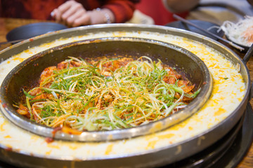 韓国料理のチーズタッカルビを食べる女性
