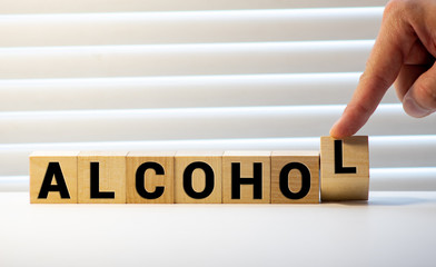 alcohol word written on wood block. alcohol text on table, concept.