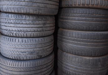 Tires for sale at a tire store - two stacks of old used tires. Dirty car tires