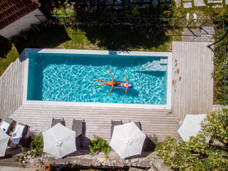 two person swim in the pool at the hotel. View from above, couple men and women in swimming pool of...