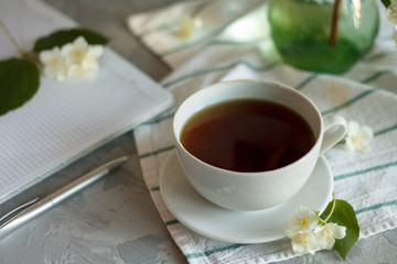 a Cup of tea and Jasmine flowers on the table on a spring morning