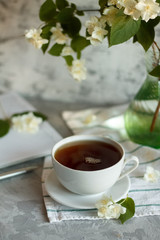 a Cup of tea and Jasmine flowers on the table on a spring morning