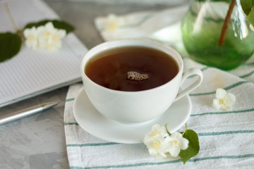 Fototapeta na wymiar a Cup of tea and Jasmine flowers on the table on a spring morning