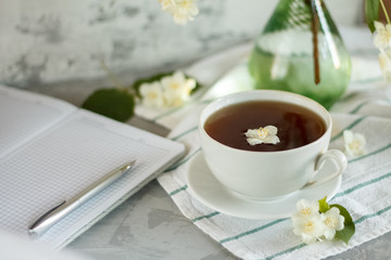 a Cup of tea and Jasmine flowers on the table on a spring morning