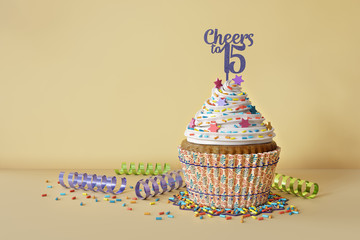 3D rendering of cupcake, text Cheers to 15 on a topper, yellow background