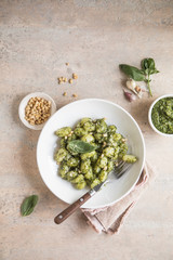 Italian food: homemade gnocchi with pesto sauce Parmesan and basil on concrete  table