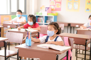 Child with face mask going back to school after covid-19 quarantine and lockdown.Asian children wear mask to protection for coronaviruscovid-19 in the school . Portrait of Thai student.