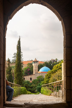 Excavation at Byblos, Lebanon. Panoramic view of Sultan Abdul Majid Mosque from the castle arch. Beautiful cypresses and flowering trees
