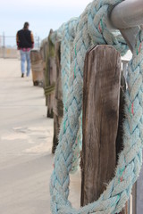 Fishing pier with wooden fence and nautical rope