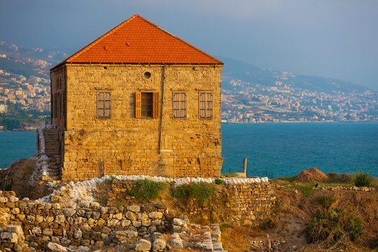 Excavations of Byblos, Lebanon. Traditional Lebanese house on the shores of the Mediterranean Sea. Seascape with blue water at sunset.