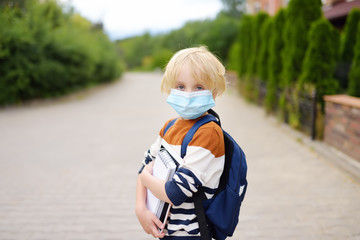 Child wearing face mask going at reopen school after covid-19 quarantine and lockdown. It is new...