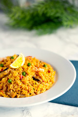 Spanish paella. White background, green textures and blue napkin