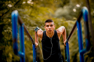 Fototapeta premium Sportsman with earphones training in the park