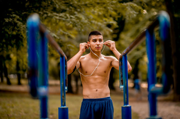 Obraz premium Sportsman with earphones training in the park