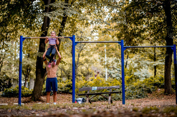 Young man and girl are training in the park