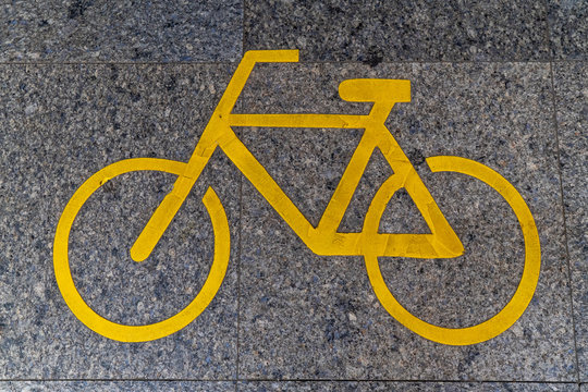 yellow bike lane sign on road tile