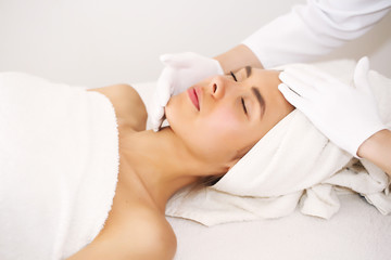 Fototapeta na wymiar Facial massage. Beautiful young woman relaxing with hand massage in beauty spa.