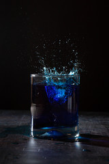 glass of water on dark background with a splash