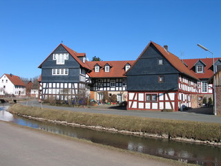 Dorfidylle in Amöneburg mit blauem Himmel, Hessen. Fachwerkhäuser mit Schiefer. Alter Bauernhof