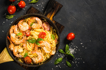 Pasta seafood with shrimp on black table.