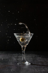 martini cocktail with olive splash