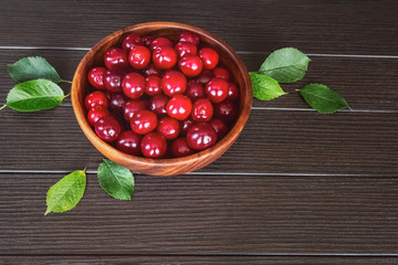 ripe cherry berries in a wooden bowl on the table close-up above. background with fresh cherry berries. cherry on the table.
