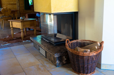 Fireplace and wooden basket in an vintage cottage