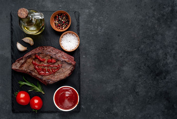 Grilled beef steak with spices for Halloween on stone background with copy space for your text