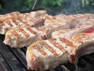 pork steaks on the bone on the grill. delicious pork loin steaks on the bone.