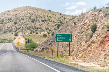 New Mexico, USA countryside rural road view from 380 highway with desert landscape and sign for...